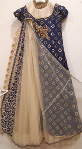 Traditional outfit with blue and gold embroidered top and beige skirt on a white background